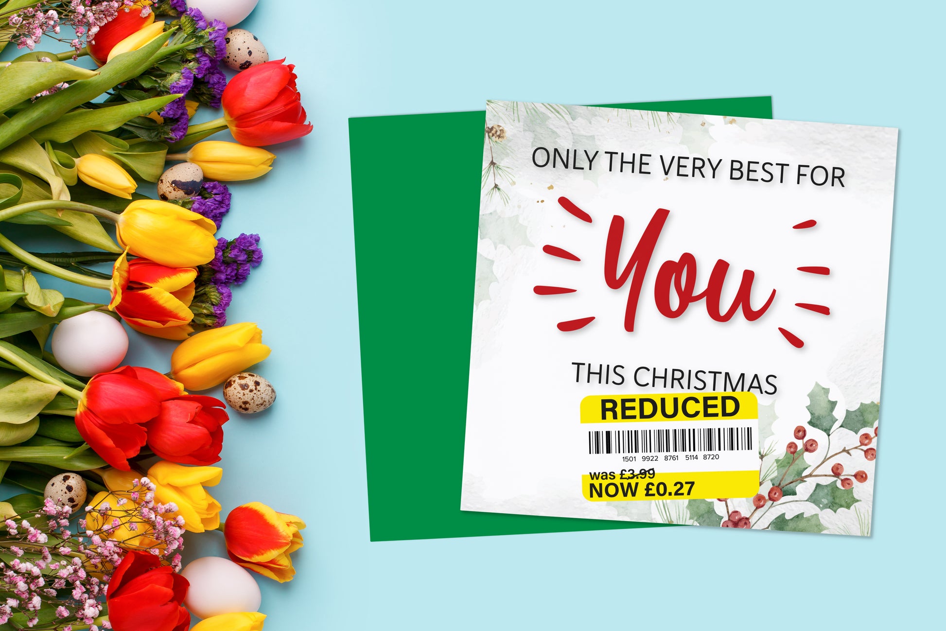 A greetings card on a blue background accompanied by flowers